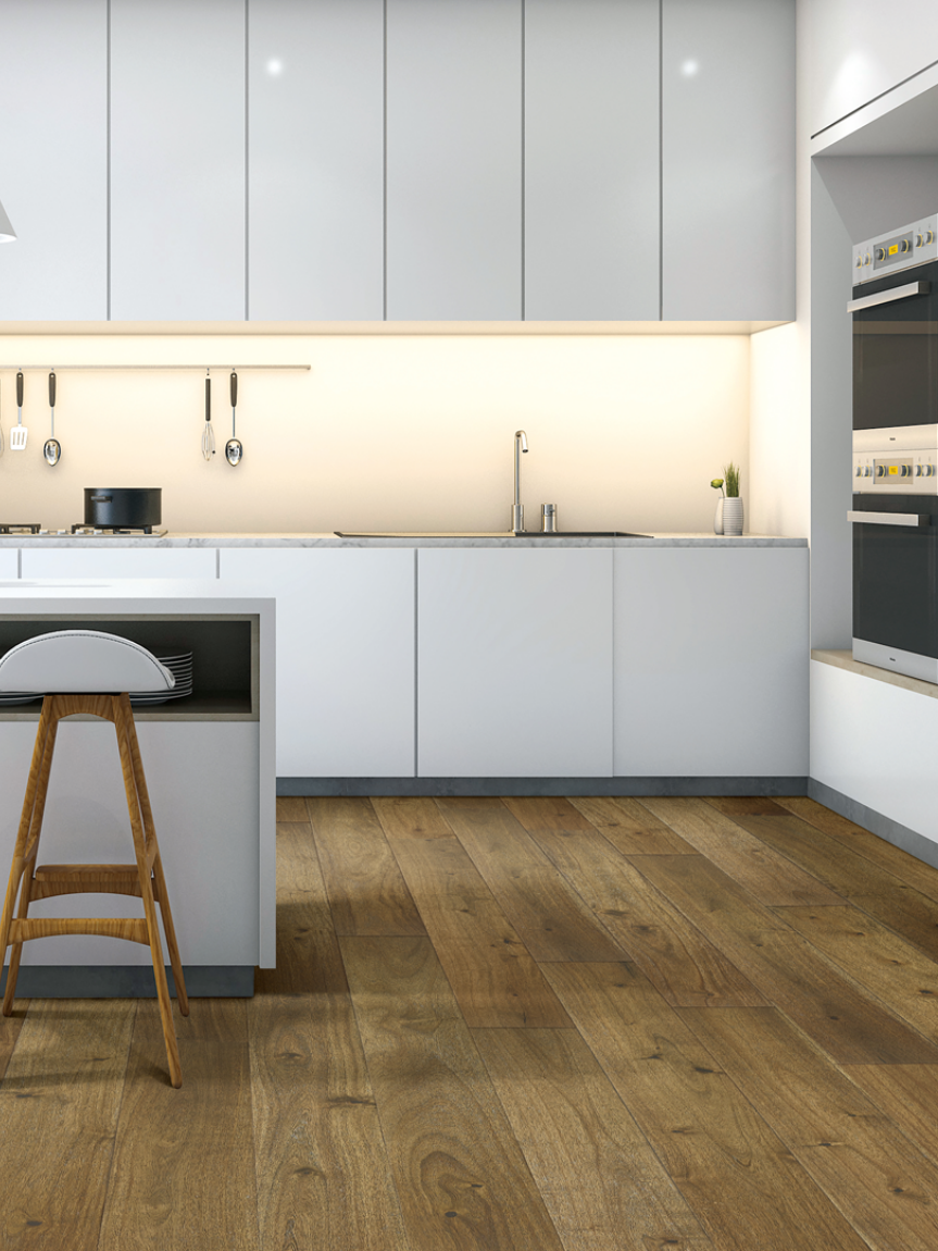 Woman sitting on a hardwood floor with a coffee mug in her hand.